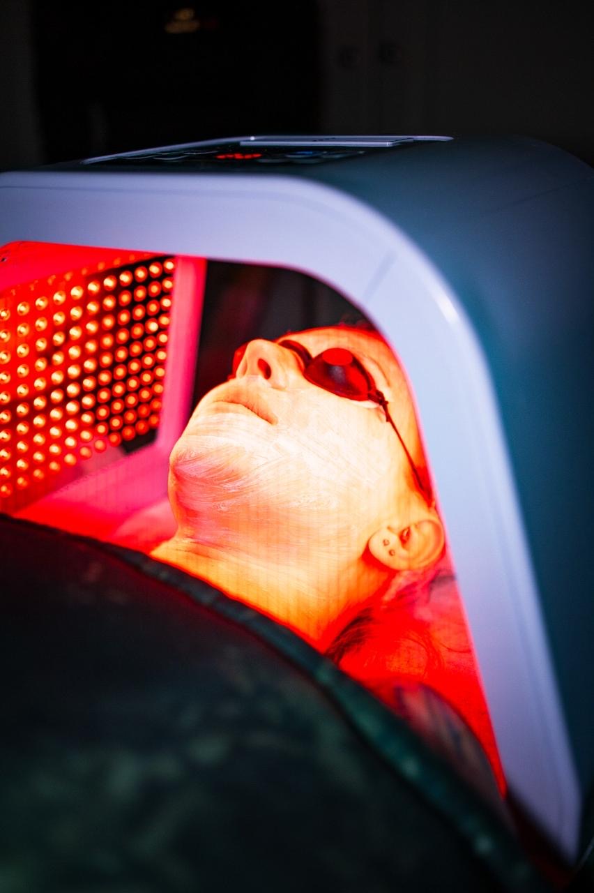 Red LED light therapy with protective eyewear during a facial