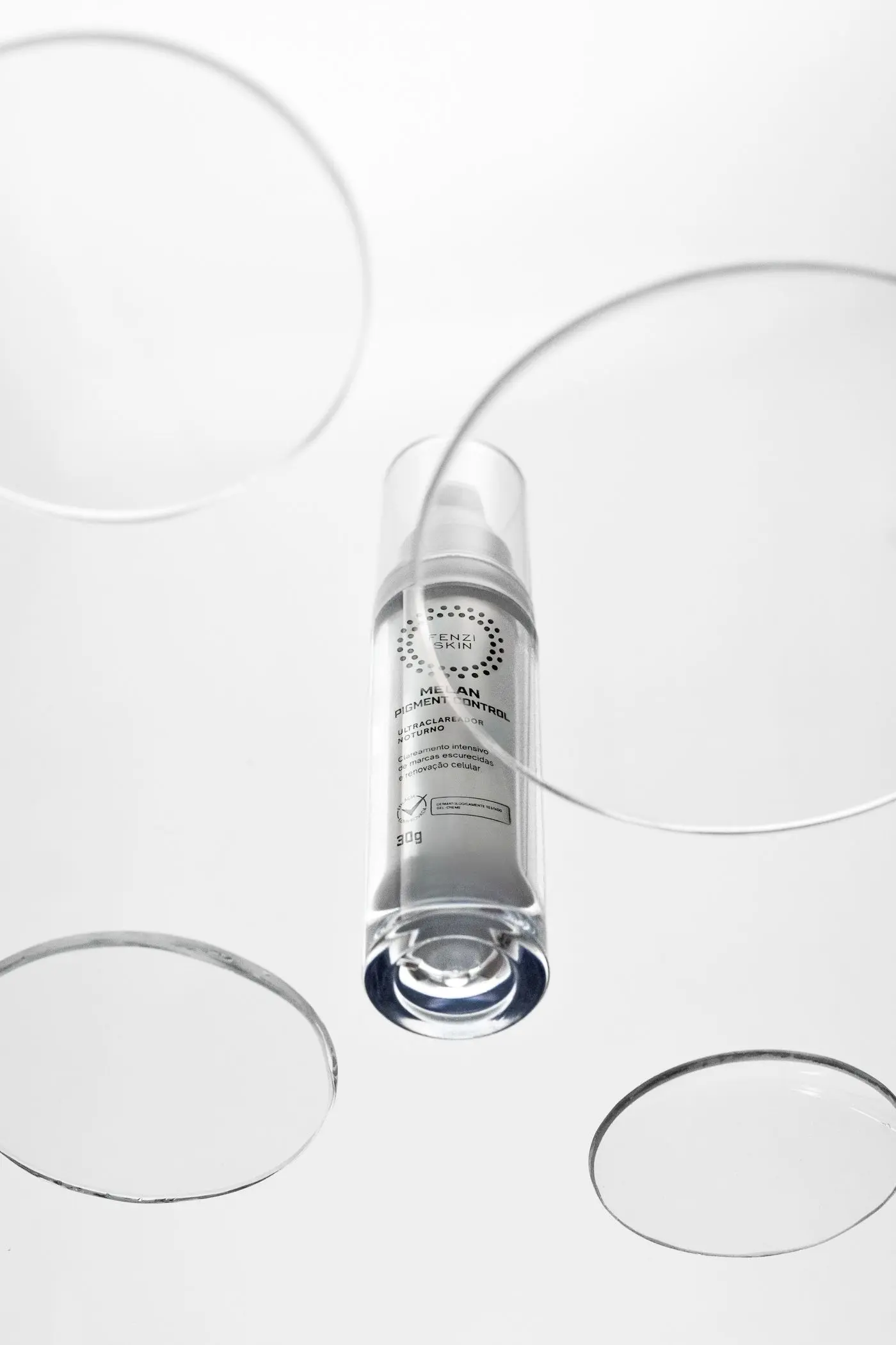 A clear serum bottle with water droplets on a pale background