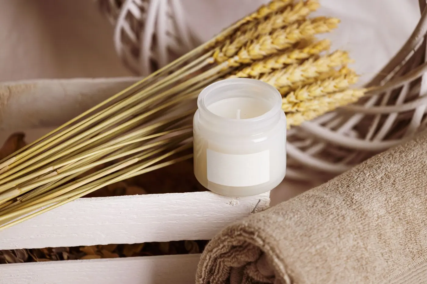 An unbranded cream jar with linen, a brush and dried stems